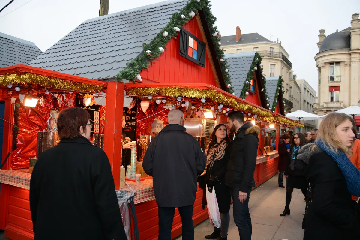 Chalets rouges décorés du marché de Noël d'Angers et visiteurs