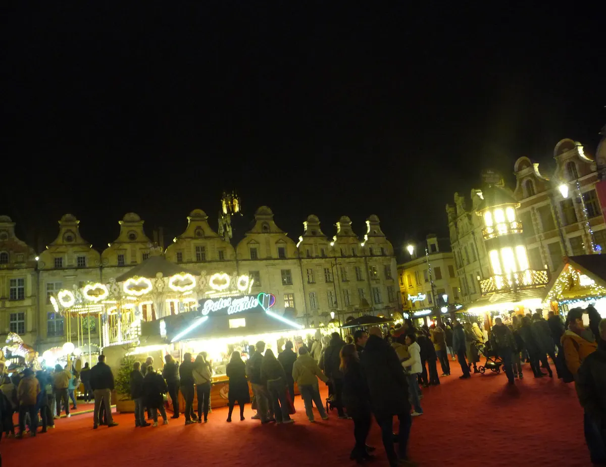 Chalets illuminés et foule sur la Grand'Place d'Arras pendant la Cité de Noël