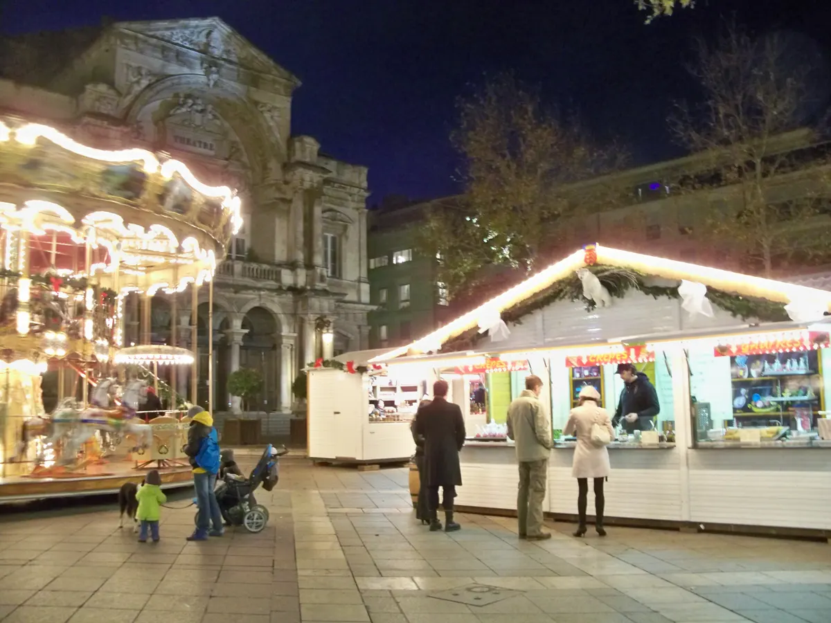 Manège et chalets blancs du marché de Noël d'Avignon devant l'Opéra