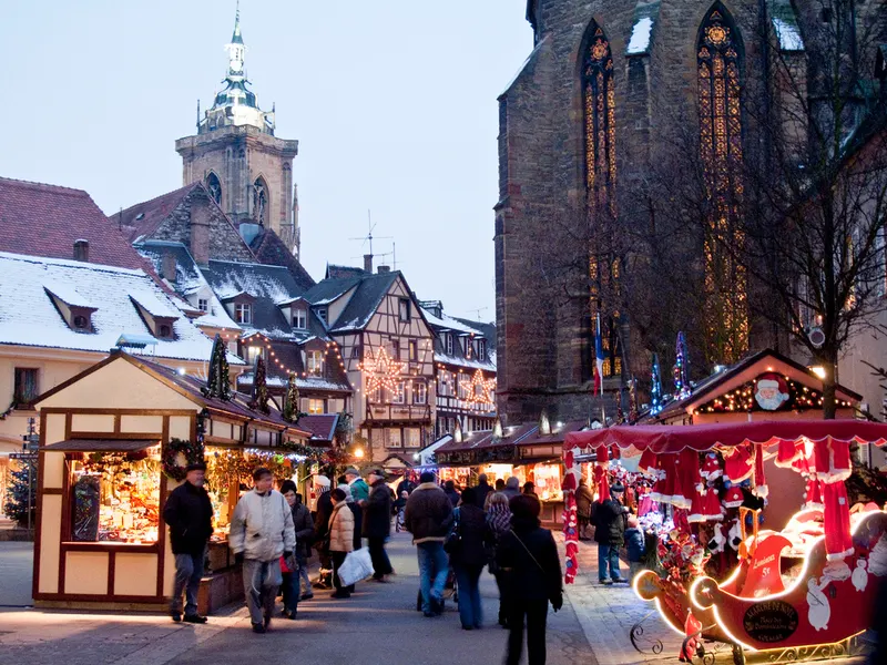 Chalets rouges et maisons à colombages enneigées au marché de Noël de Colmar