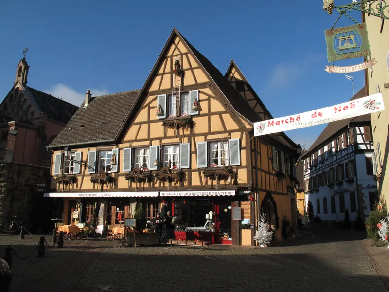Maisons à colombages illuminées de guirlandes à Eguisheim pendant le marché de Noël
