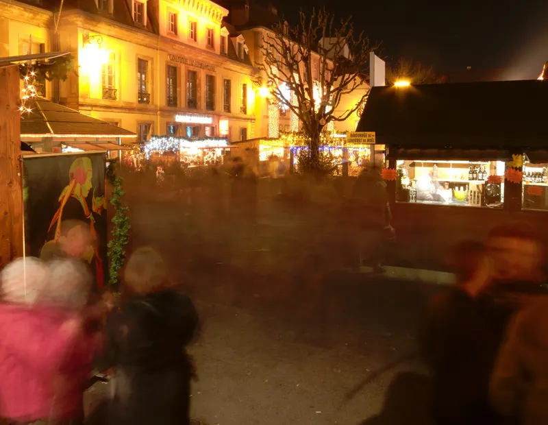 Église éclairée et chalets en bois au marché de Noël de Montbéliard