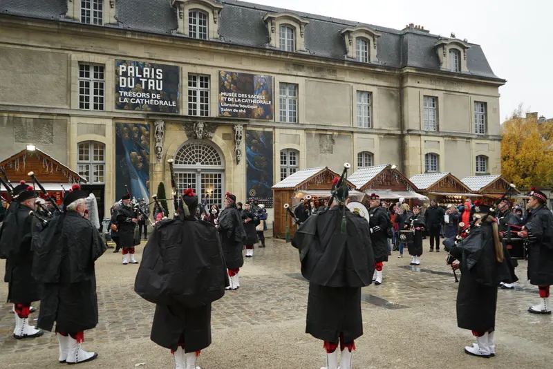 Joueurs de cornemuse devant le Palais du Tau au marché de Noël de Reims