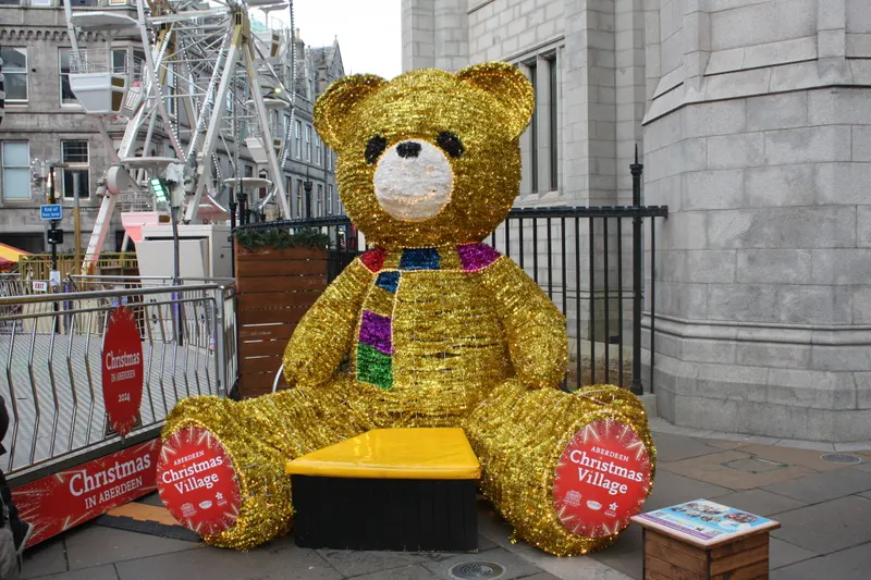Giant golden teddy bear and Christmas Village sign in Aberdeen