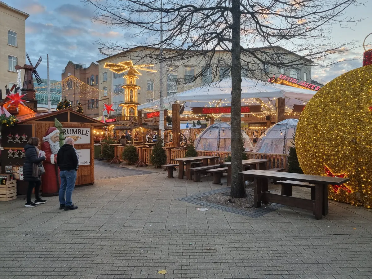 Festive wooden stalls and lit pyramid at Bristol Christmas Market in Broadmead
