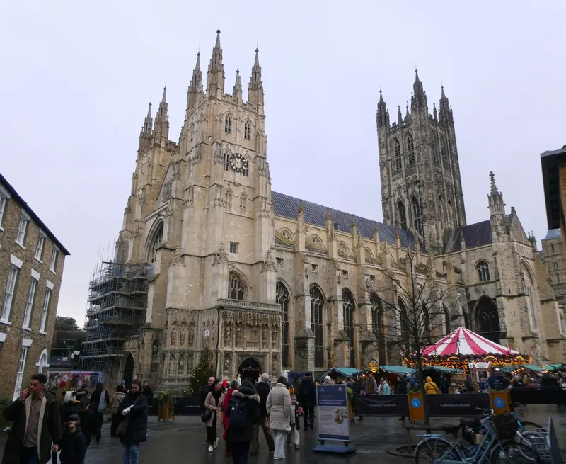 Canterbury Cathedral with Christmas market stalls and a carousel in front