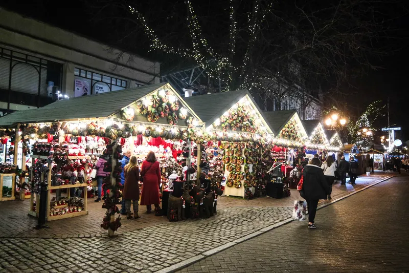 Lit-up Christmas market stalls at night in Chester