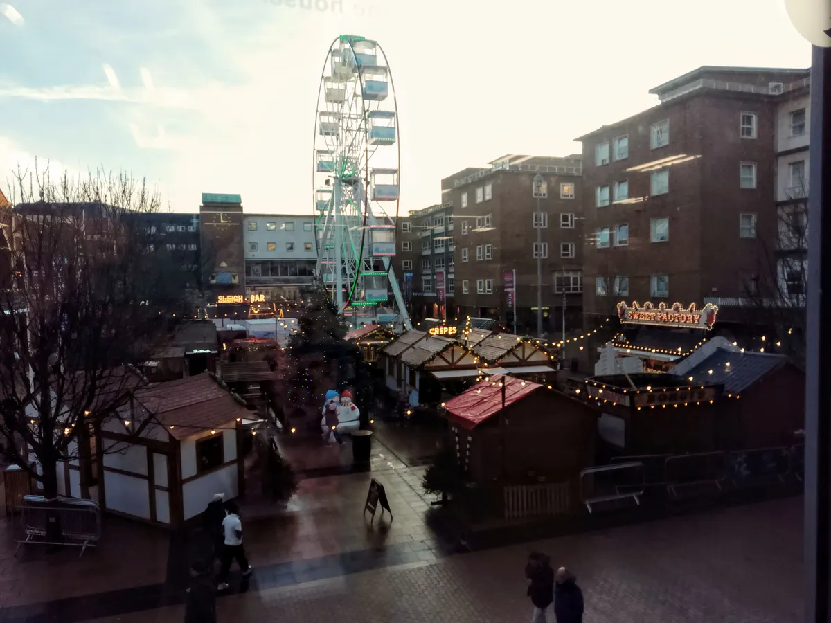 Coventry Christmas Market chalets with a big wheel behind