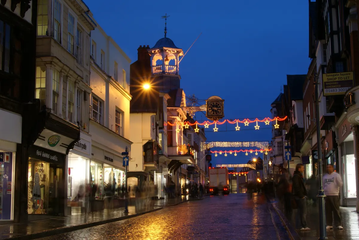 Guildford High Street at dusk with Christmas lights strung overhead