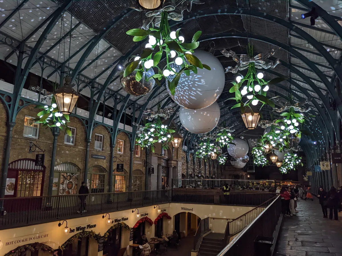 Mistletoe and bauble decorations hanging in Covent Garden Market hall at Christmas