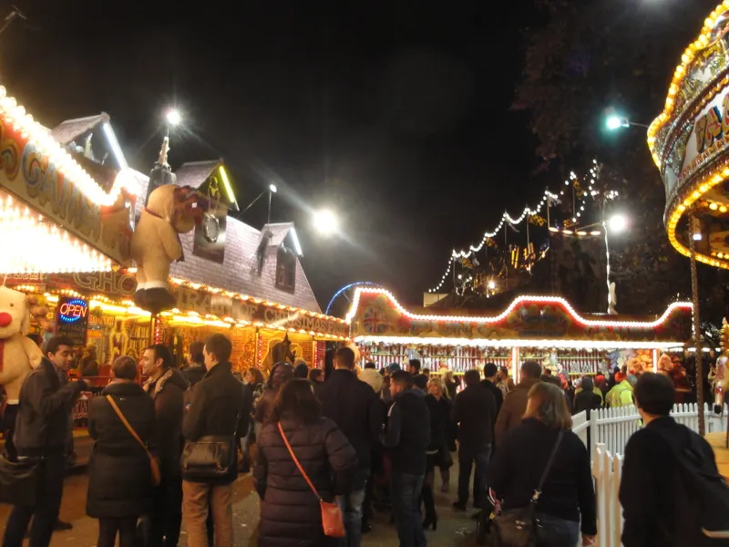 Crowds and illuminated stalls at Winter Wonderland in Hyde Park