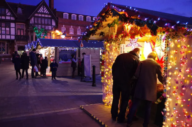 Visitors at a glowing chalet at Salisbury Christmas Market