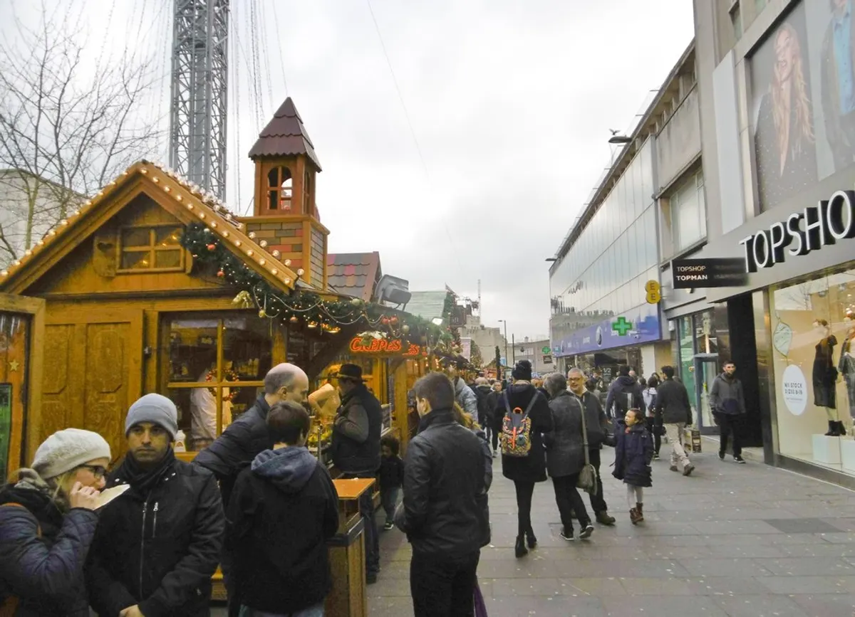 Wooden chalet and shoppers at Southampton Christmas Market