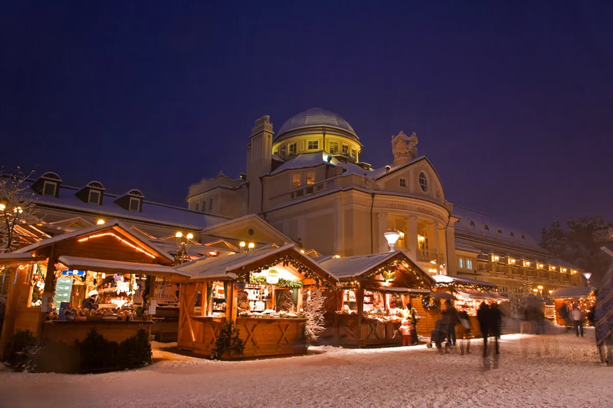 Il Kurhaus di Merano con le casette del Mercatino di Natale sotto la neve