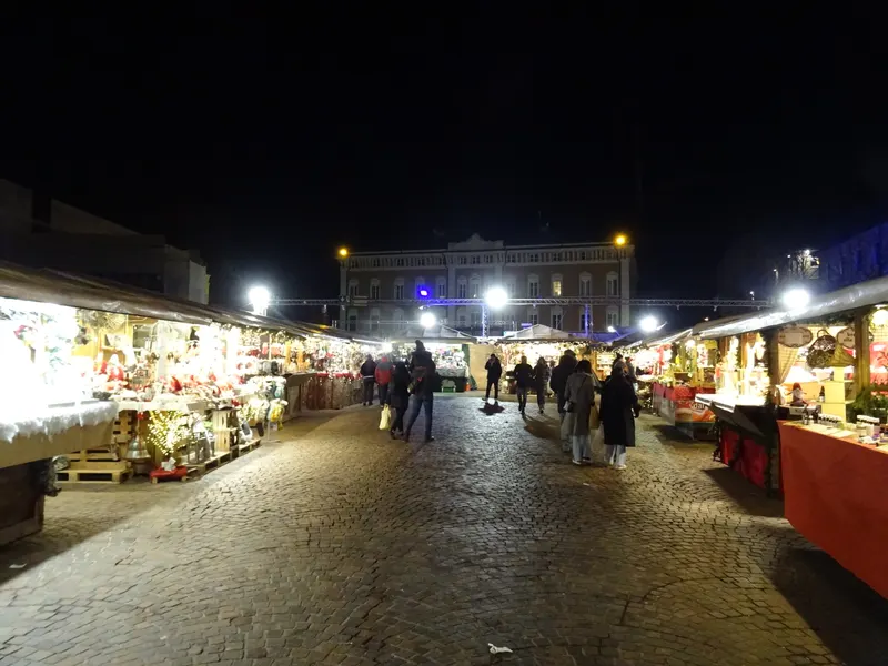 Viale di casette illuminate ai Mercatini di Natale di Trento