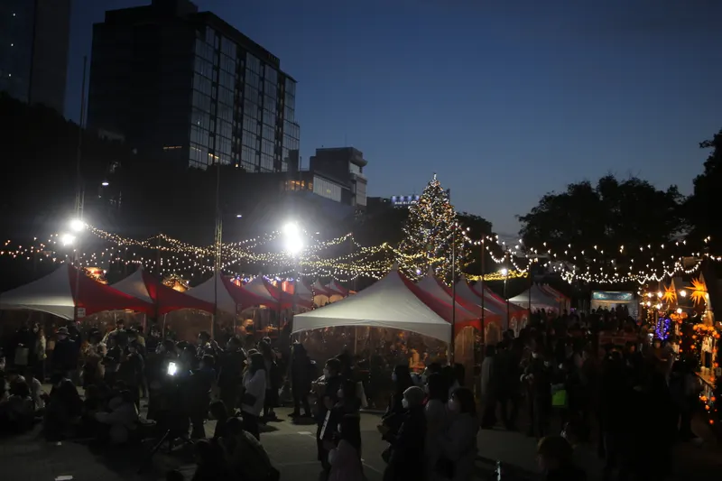 夕暮れの久屋大通公園に並ぶ名古屋クリスマスマーケットのテントと電飾