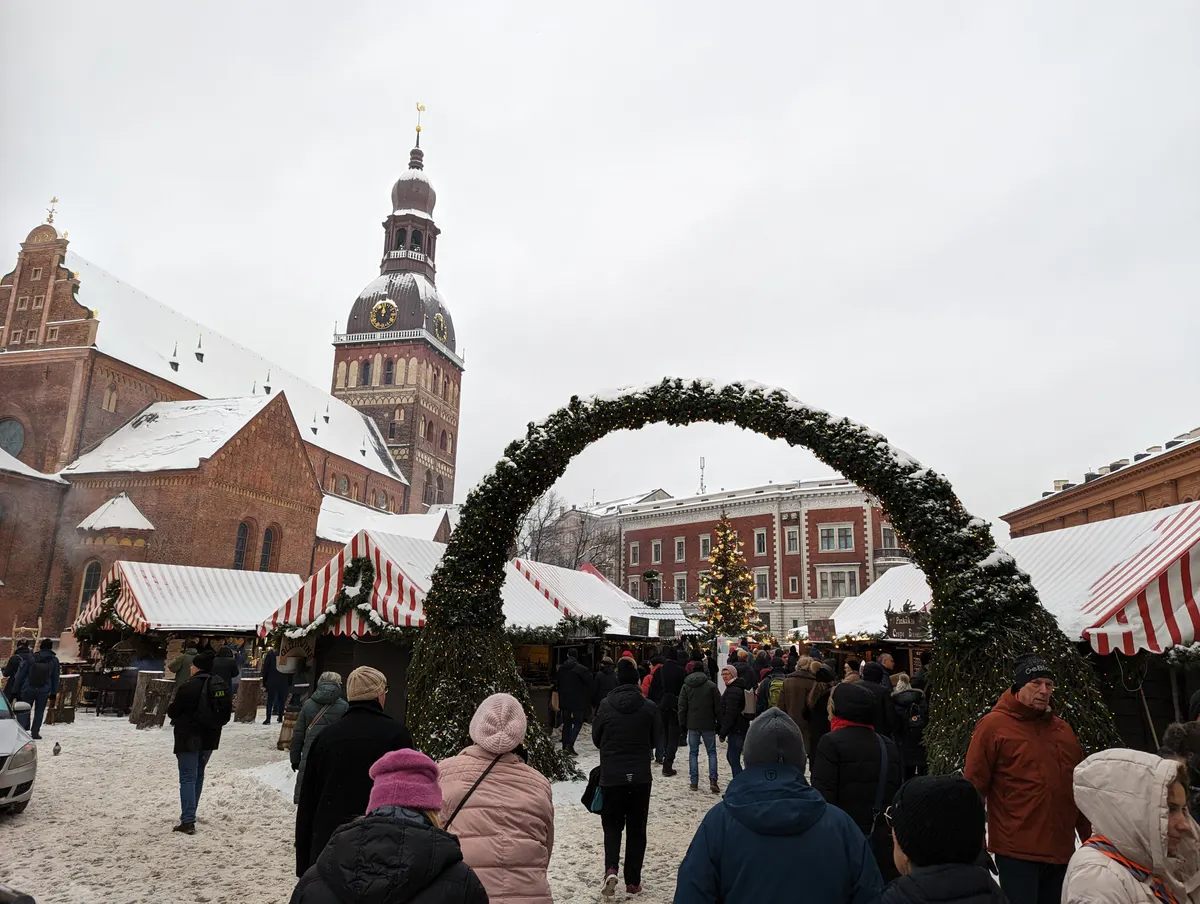 Ziemassvētku tirdziņš Doma laukumā Rīgā ar egļu zaru velvi un Doma baznīcu