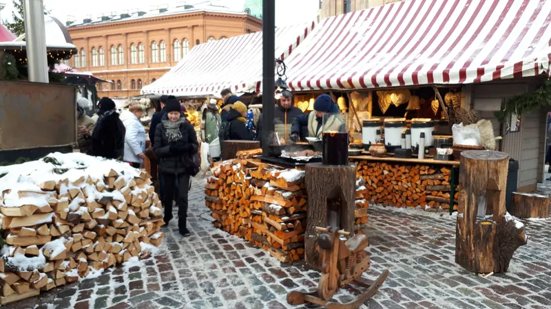 Ziemassvētku tirdziņa nojume ar malku un svētku kārumiem Rīgā