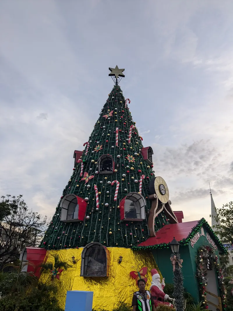 Giant decorated Christmas tree with red windows against the evening sky in Mandaue
