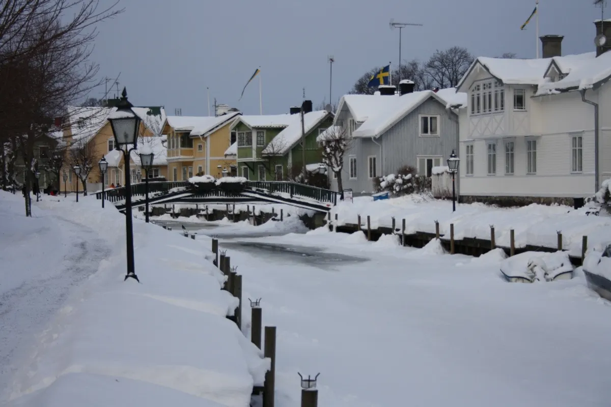 Snötäckta hus vid ån i Trosa i juletid