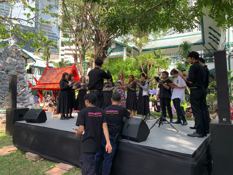 คณะนักร้องประสานเสียงบนเวทีกลางสวนในงานตลาดคริสต์มาสเยอรมัน กรุงเทพฯ