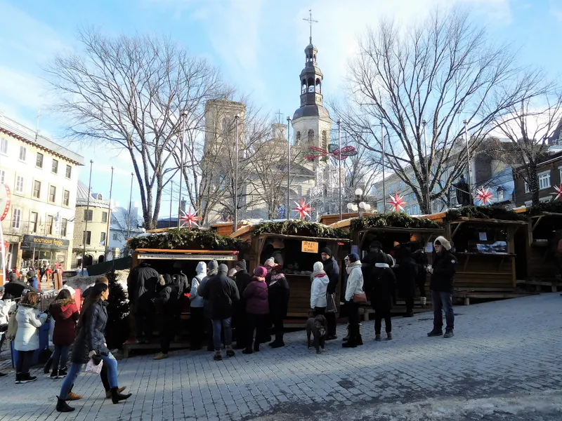 File devant un chalet du Marché de Noël allemand, avec la basilique-cathédrale en arrière-plan
