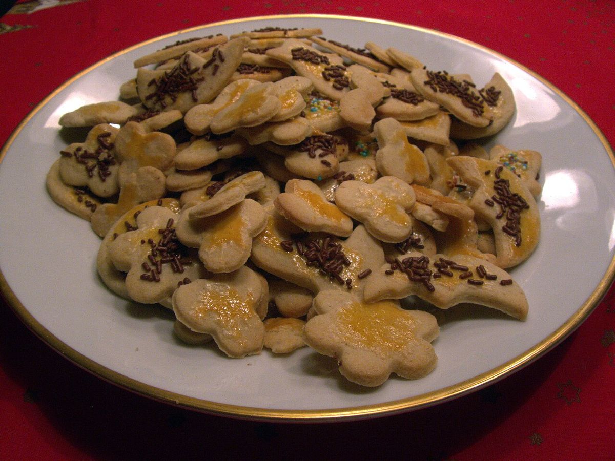 Teller mit selbstgebackenen Weihnachtsplätzchen und Streuseln