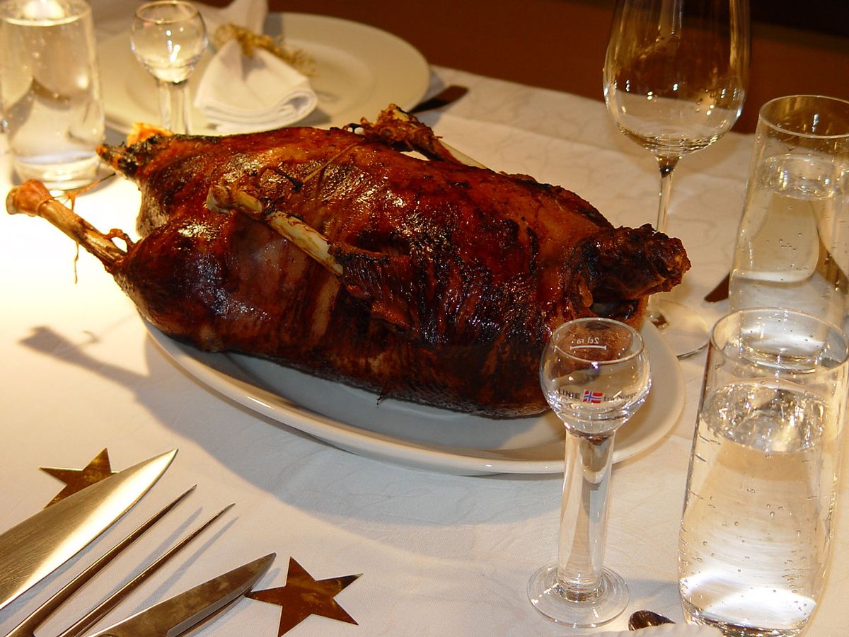 Gebratene Weihnachtsgans auf einer Platte am gedeckten Tisch